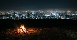 A small ancient fire in the foreground against a vast modern city skyline at night — visualising the full arc of human history from Sapiens by Yuval Noah Harari